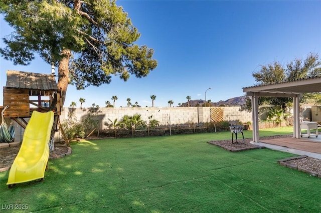 view of yard with a fenced backyard, a playground, and a patio