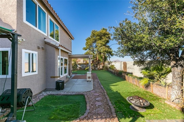 view of yard featuring an outdoor fire pit, a fenced backyard, and a patio