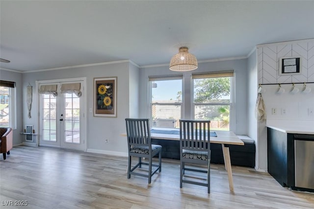 dining space with light wood finished floors, ornamental molding, and plenty of natural light