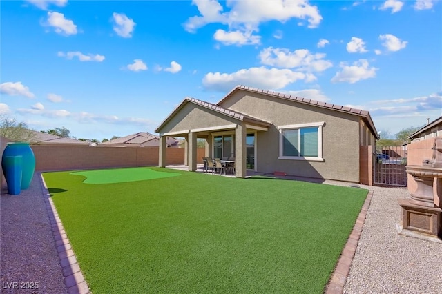 back of property featuring a yard, a fenced backyard, a patio, and stucco siding