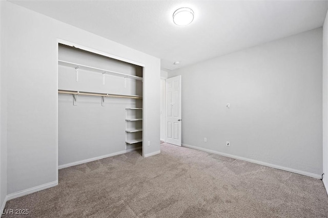 unfurnished bedroom featuring a closet, carpet flooring, and baseboards