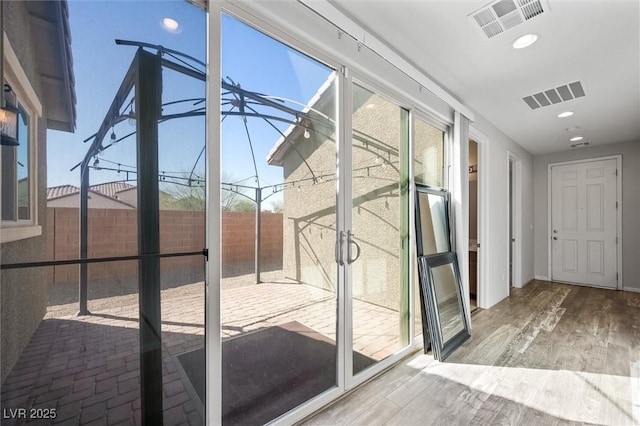 entryway with recessed lighting, visible vents, baseboards, and wood finished floors