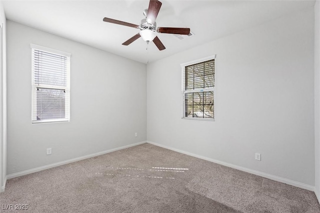 carpeted empty room featuring baseboards and a ceiling fan