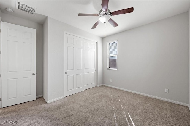 unfurnished bedroom with a closet, carpet, visible vents, and baseboards