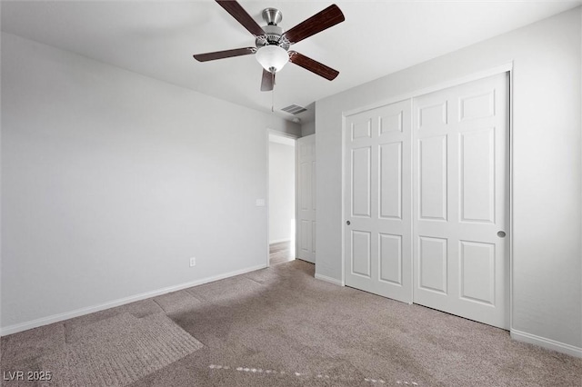 unfurnished bedroom with baseboards, visible vents, a ceiling fan, carpet floors, and a closet