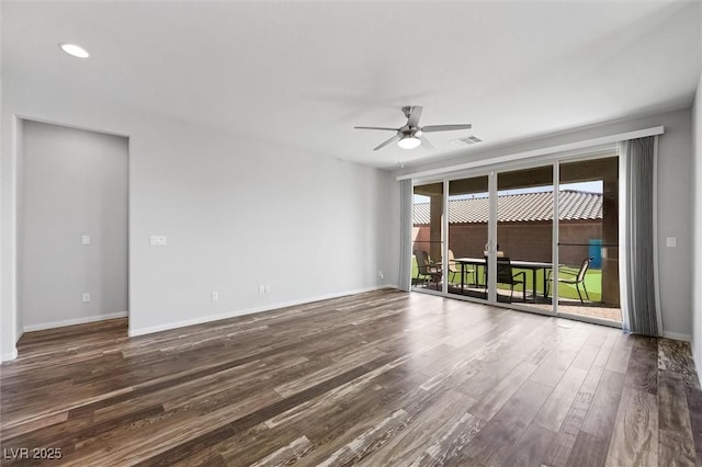 empty room featuring ceiling fan, wood finished floors, visible vents, and baseboards