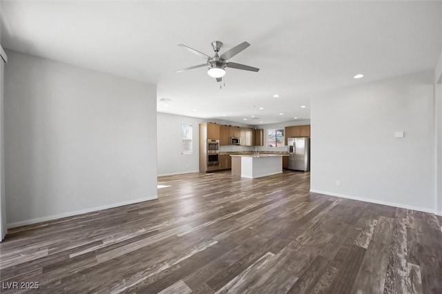 unfurnished living room featuring baseboards, dark wood-style floors, ceiling fan, a sink, and recessed lighting