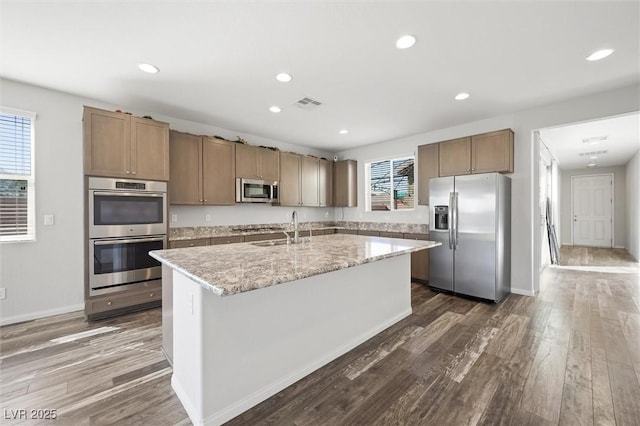 kitchen with dark wood-style floors, visible vents, appliances with stainless steel finishes, and a sink