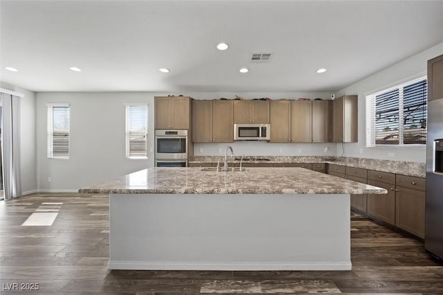 kitchen with dark wood-style floors, visible vents, appliances with stainless steel finishes, and a sink