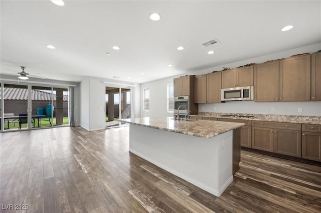 kitchen featuring appliances with stainless steel finishes, dark wood-style flooring, and a healthy amount of sunlight