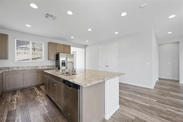 kitchen with stainless steel appliances, recessed lighting, visible vents, a kitchen island with sink, and a sink