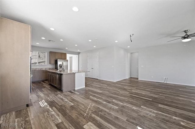 kitchen featuring dark wood finished floors, a center island with sink, recessed lighting, open floor plan, and baseboards