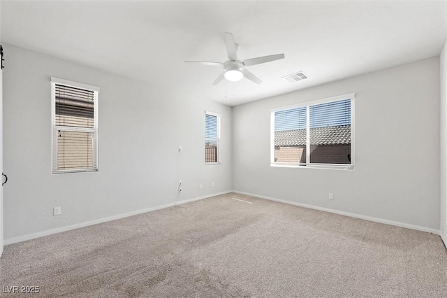 unfurnished room with baseboards, carpet, visible vents, and a ceiling fan