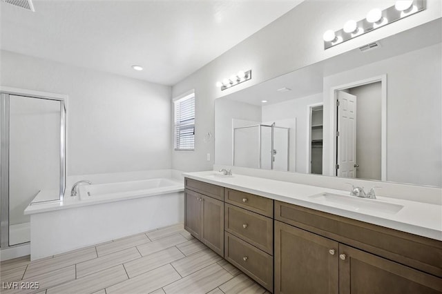 full bath featuring a garden tub, a sink, visible vents, a shower stall, and double vanity