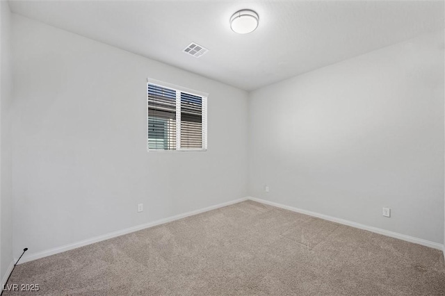 unfurnished room with carpet floors, visible vents, and baseboards