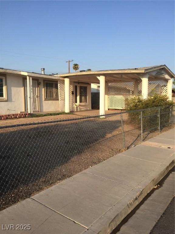 ranch-style home with fence and stucco siding