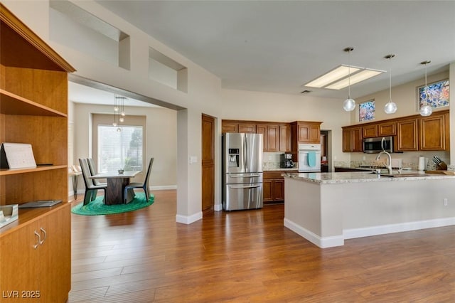 9816 Gerald Ct, Las Vegas, NV 89134 - kitchen featuring stainless steel appliances, decorative light fixtures, dark wood-style floors, and brown cabinetry