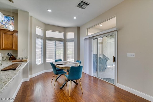 dining room with dark wood-style floors, recessed lighting, visible vents, and baseboards