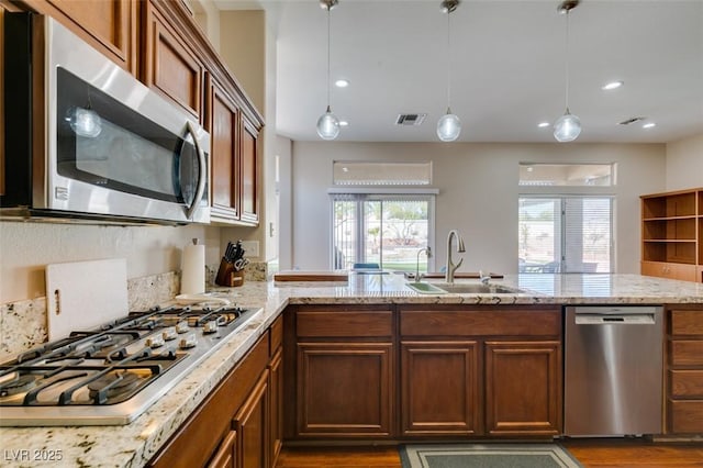 9816 Gerald Ct, Las Vegas, NV 89134 - kitchen featuring appliances with stainless steel finishes, light stone countertops, wood finished floors, hanging light fixtures, and recessed lighting