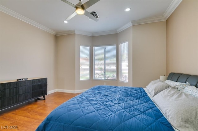 bedroom featuring baseboards, visible vents, ornamental molding, and wood finished floors