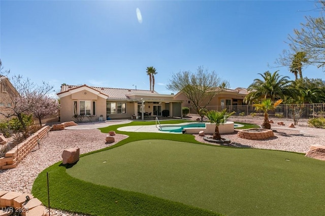 rear view of house with fence, a tiled roof, a fenced in pool, stucco siding, and a patio area