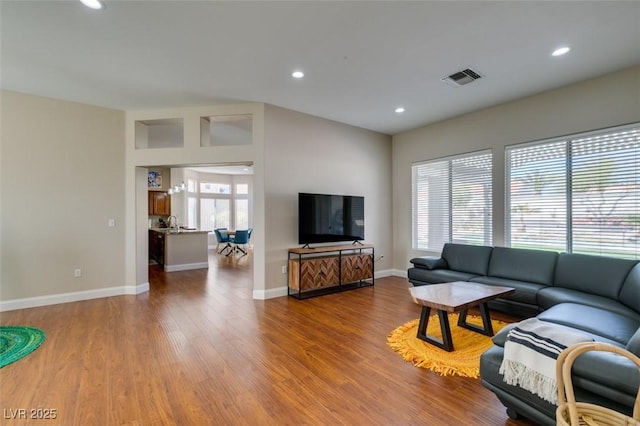 living area featuring recessed lighting, wood finished floors, visible vents, and baseboards