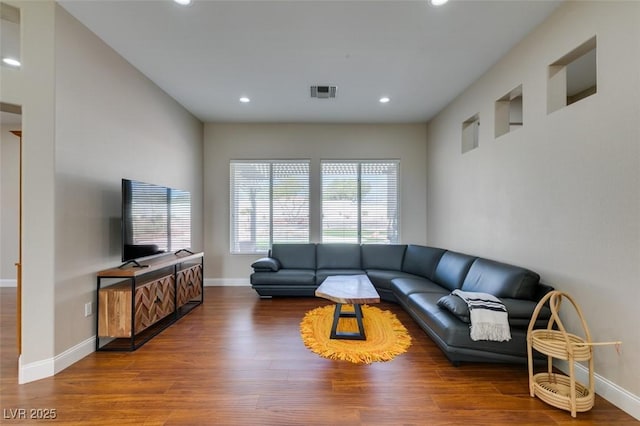 living area featuring baseboards, visible vents, wood finished floors, and recessed lighting