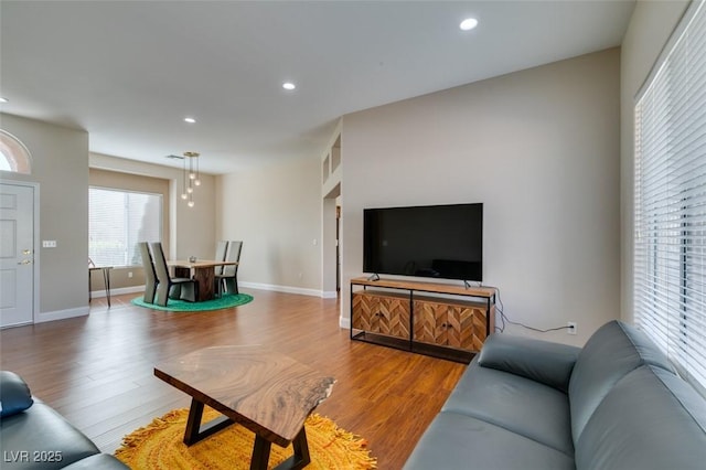 living area featuring baseboards, wood finished floors, and recessed lighting