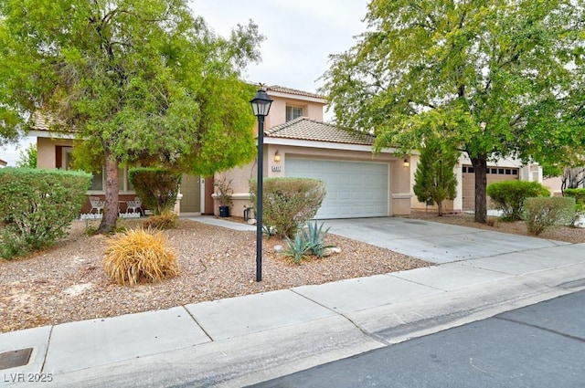 obstructed view of property with a garage, driveway, a tiled roof, and stucco siding