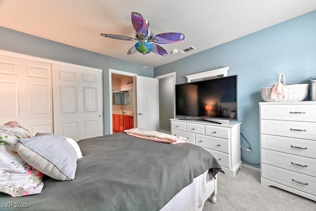 bedroom with a closet, visible vents, carpet flooring, connected bathroom, and ceiling fan