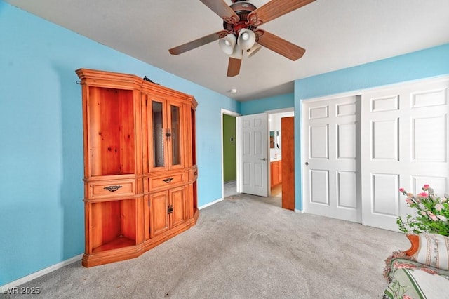 unfurnished bedroom featuring carpet floors, ceiling fan, baseboards, and a closet