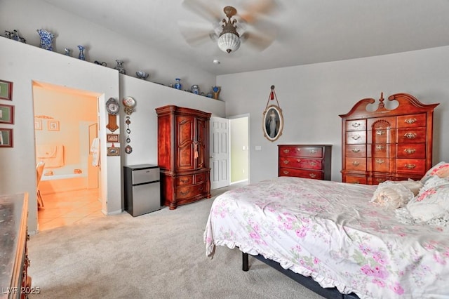 bedroom with light carpet, ensuite bath, ceiling fan, freestanding refrigerator, and vaulted ceiling