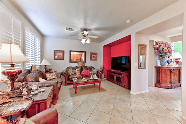 living room with light tile patterned floors, baseboards, visible vents, and a ceiling fan