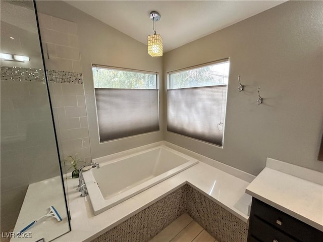 bathroom featuring vaulted ceiling, tiled shower, and a bath