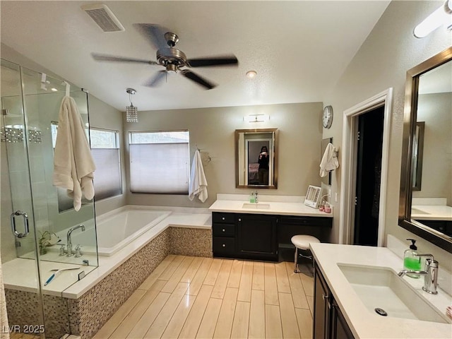 full bathroom featuring visible vents, a sink, a shower stall, and a bath