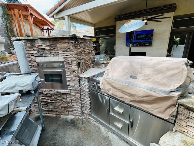 view of patio featuring ceiling fan and exterior kitchen