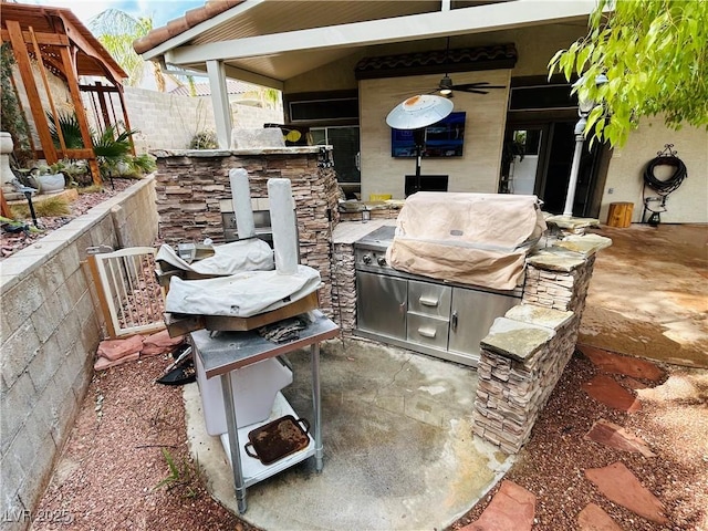 view of patio featuring grilling area, fence, and an outdoor kitchen