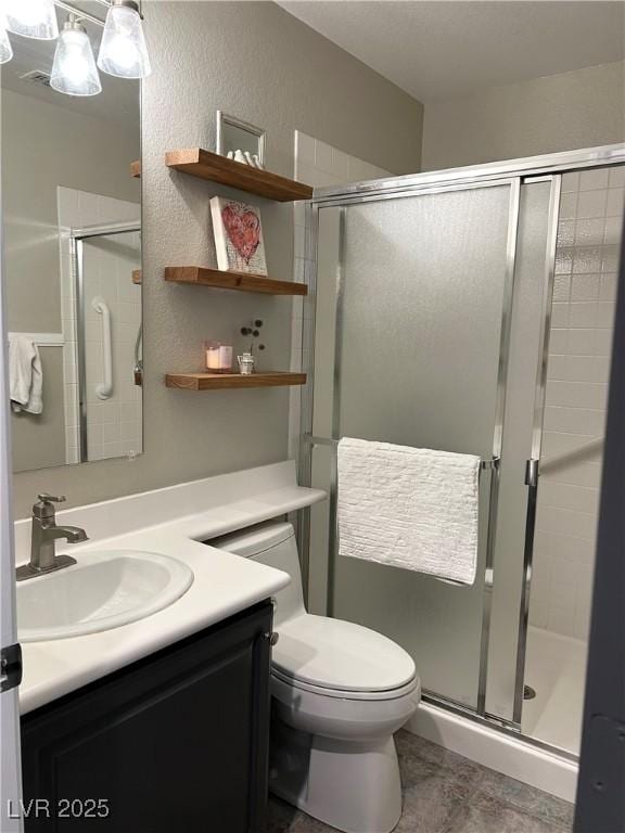 full bath featuring toilet, a stall shower, a textured wall, and vanity