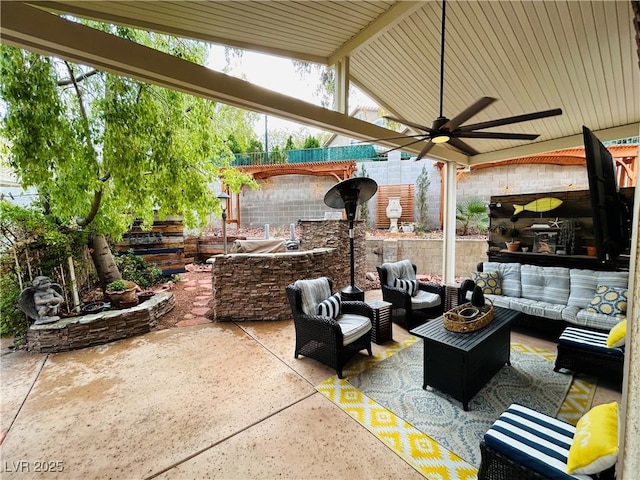 view of patio / terrace featuring fence, an outdoor hangout area, and a ceiling fan