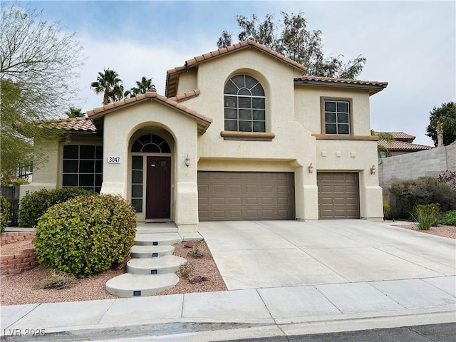 mediterranean / spanish house featuring an attached garage, driveway, a tile roof, and stucco siding