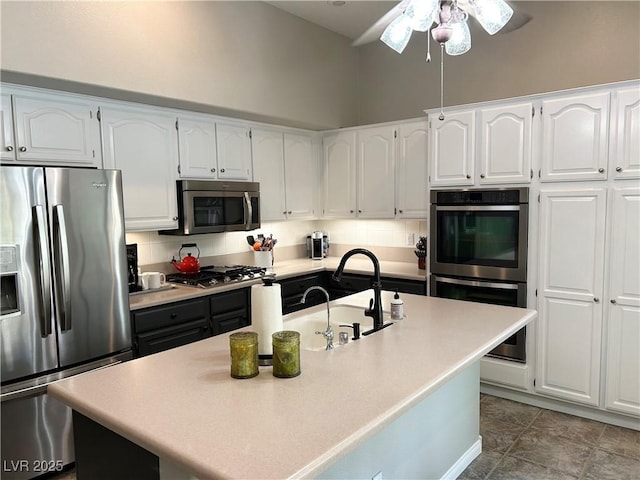 kitchen with stainless steel appliances, light countertops, white cabinetry, and a sink