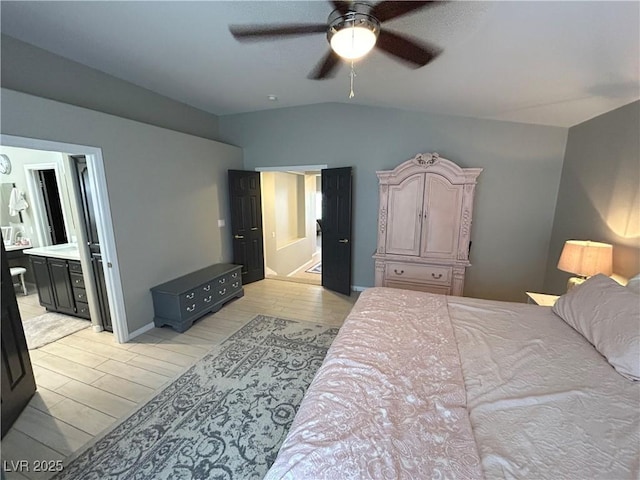 bedroom with light wood-style flooring, ensuite bathroom, a ceiling fan, vaulted ceiling, and baseboards