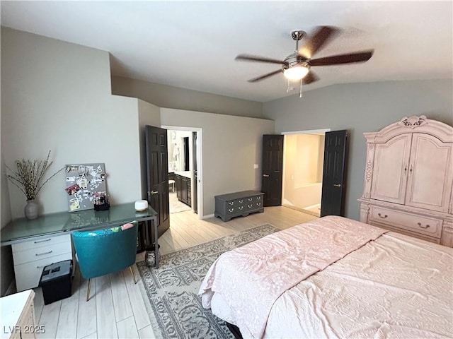 bedroom featuring ensuite bathroom, lofted ceiling, a ceiling fan, and light wood-style floors