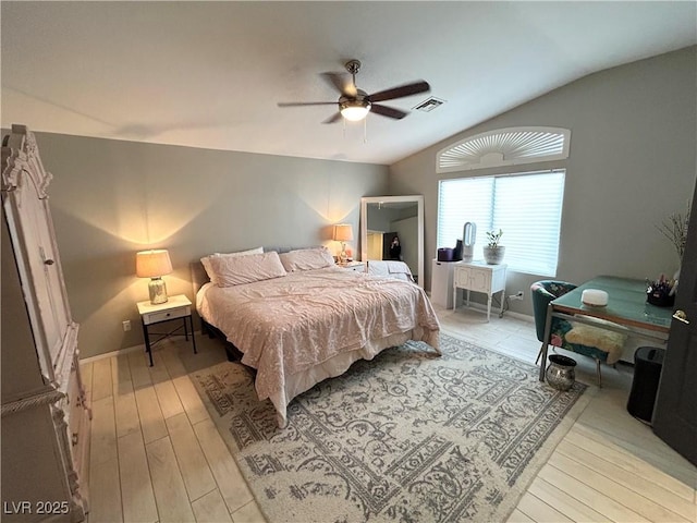 bedroom with ceiling fan, visible vents, baseboards, vaulted ceiling, and light wood-type flooring