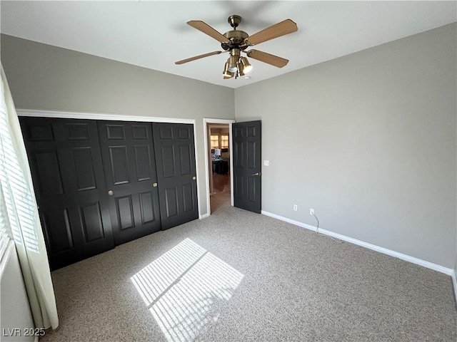 unfurnished bedroom featuring ceiling fan, a closet, carpet, and baseboards