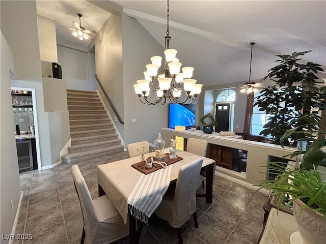 dining space featuring wine cooler, stairway, a bar, high vaulted ceiling, and ceiling fan with notable chandelier