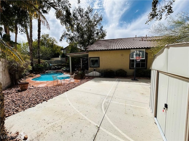 back of property with a fenced in pool, fence, stucco siding, and a patio area
