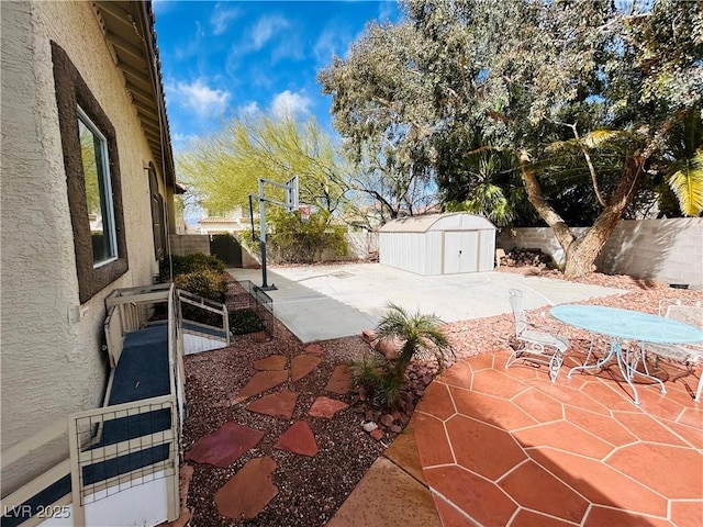 view of patio featuring a storage shed, an outdoor structure, and a fenced backyard
