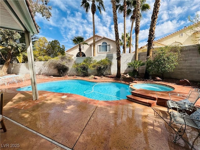 view of swimming pool featuring a fenced backyard, a pool with connected hot tub, and a patio