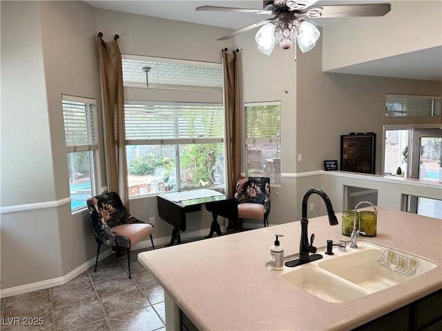 kitchen featuring light countertops, a sink, and baseboards